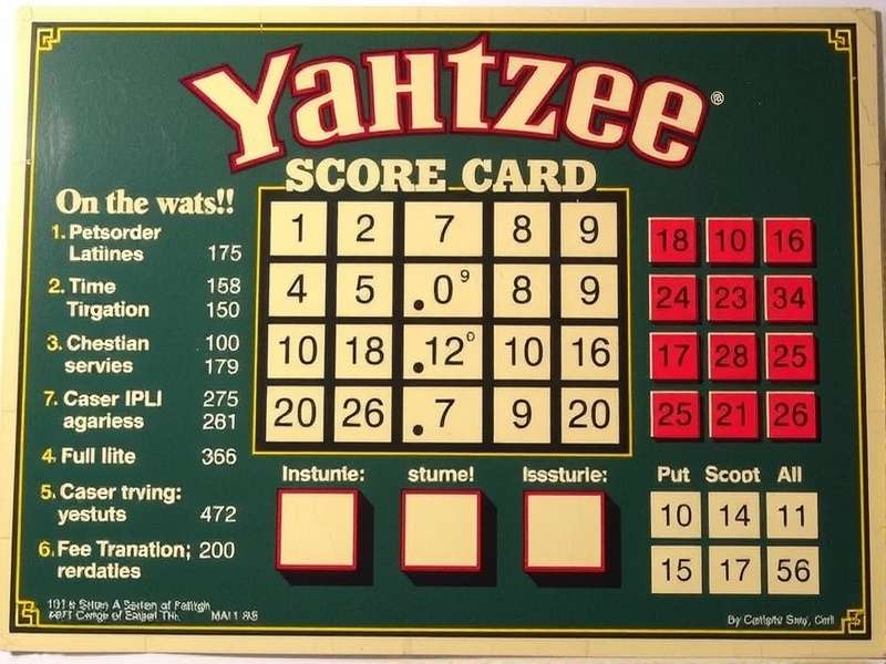 Yahtzee dice and score card on a wooden table